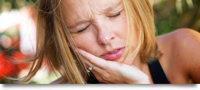 Woman with a painful toothache needs emergency dental care from an emergency dentist near Vista, CA.